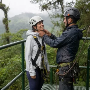 Canopy guide checking a traveler’s zipline equipment at Selvatura Park